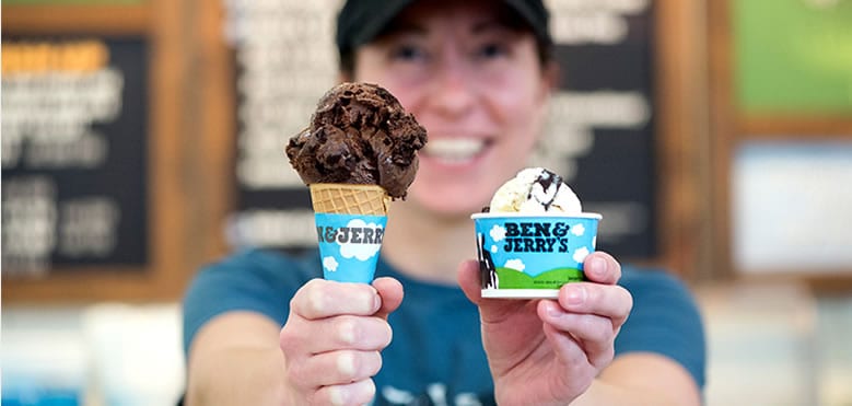 A woman holding a cup and cone of Ben & Jerry's ice cream