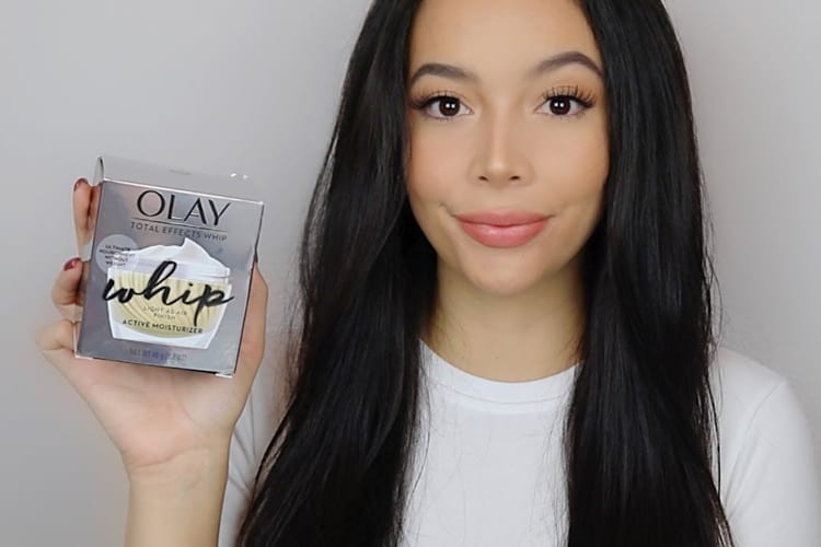 A woman holding up a box of Olay skin cream