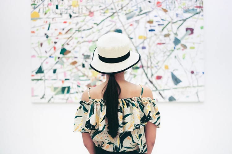 A woman in a museum looking at an abstract artwork