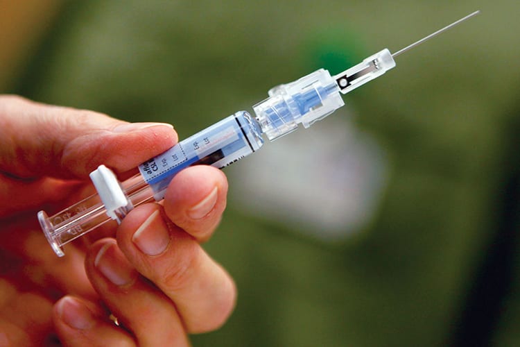 A hand holding a syringe 