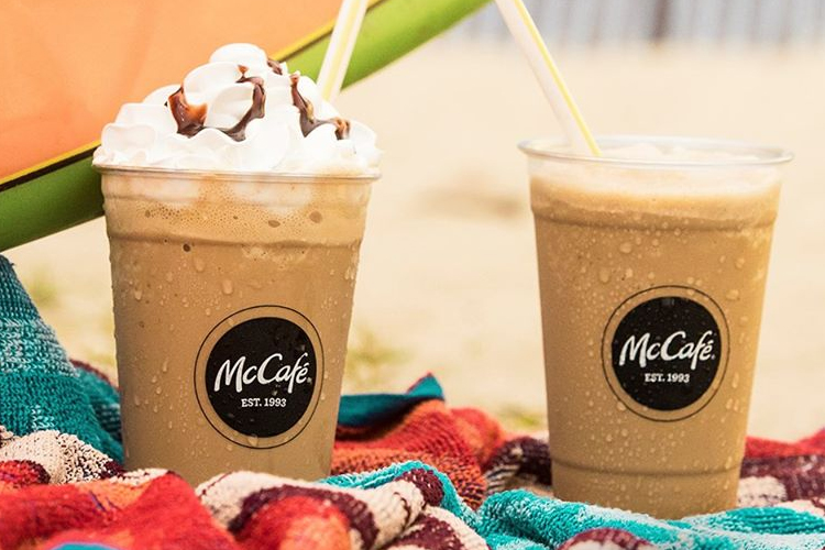 Two cups of McCafe coffees on a beach towel
