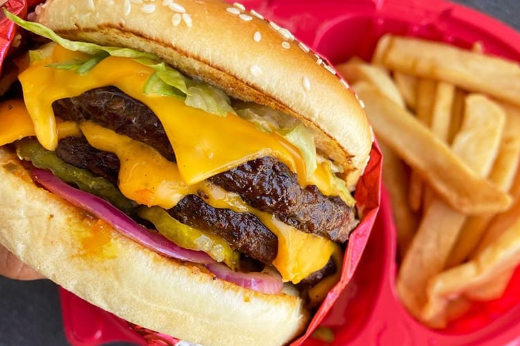 Cheeseburger and steak fries in takeout tray from Red Robin