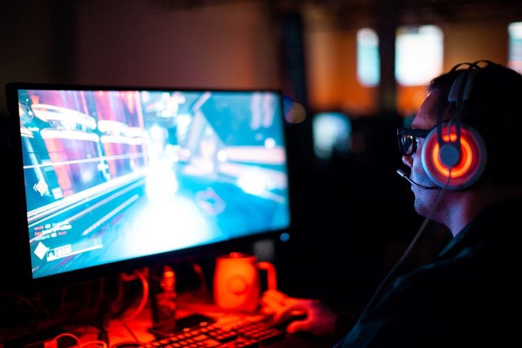 A gamer at a PC with red lights 
