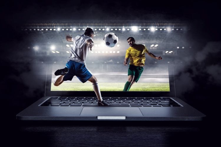 A photoshopped picture of two soccer players fighting for a ball on a laptop keyboard