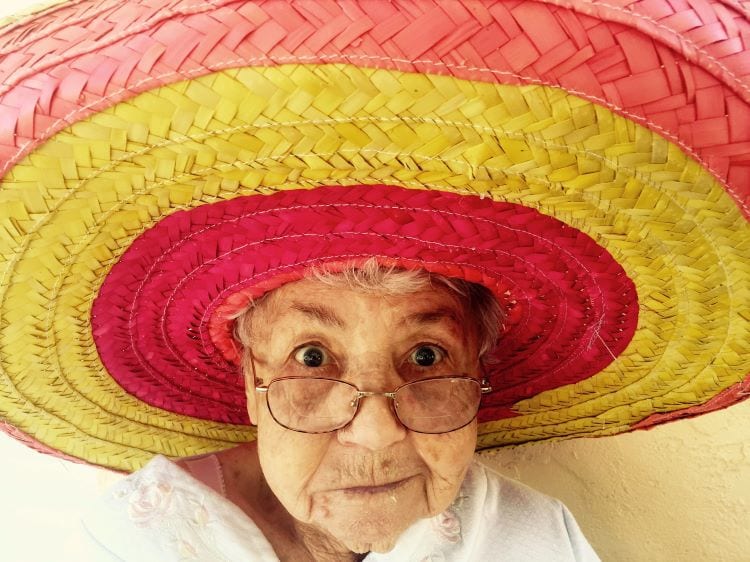 An older woman with glasses wearing a large sombrero