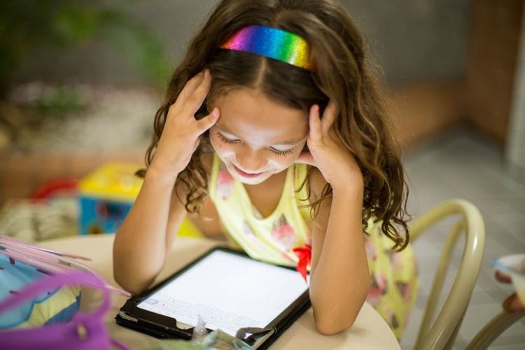 A young girl reading from an iPad