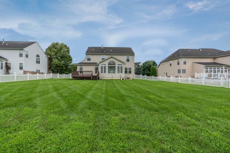A vast backyard leading to the back of a two-story home