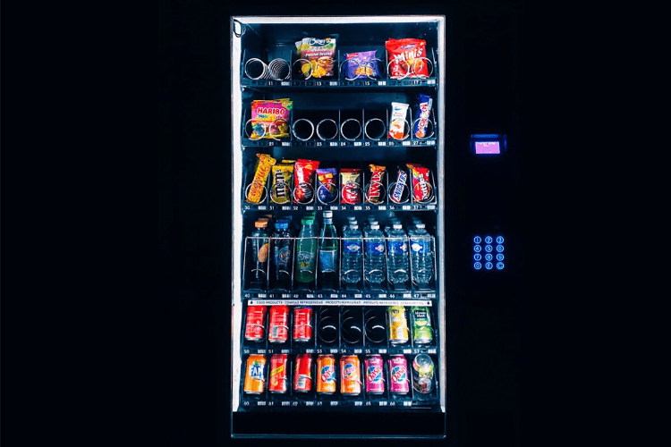 A half-full vending machine against a black background