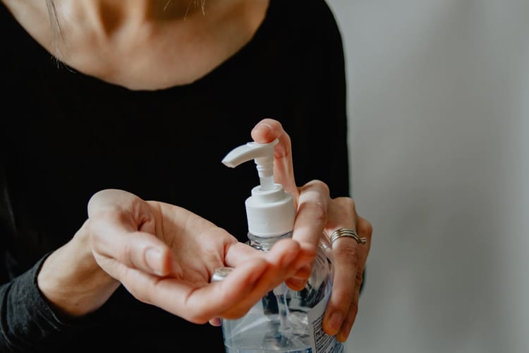 A woman using hand sanitizer