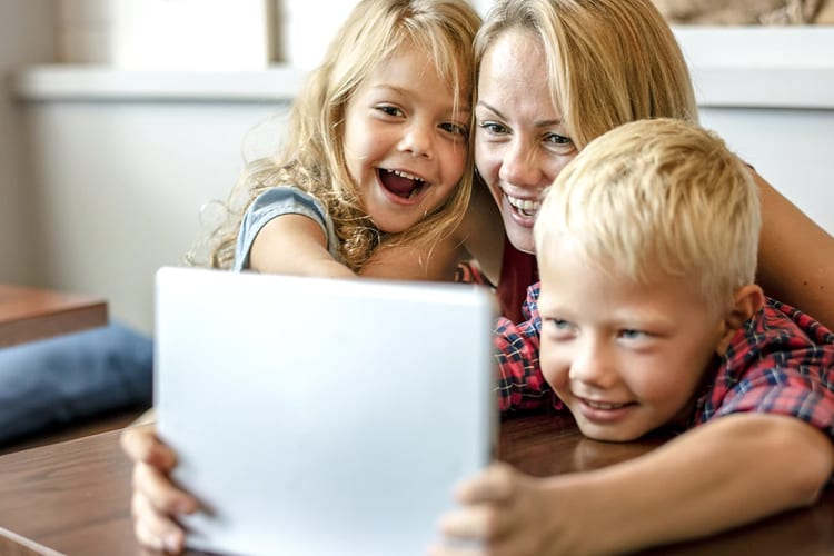 A mother with her son and daughter using a tablet