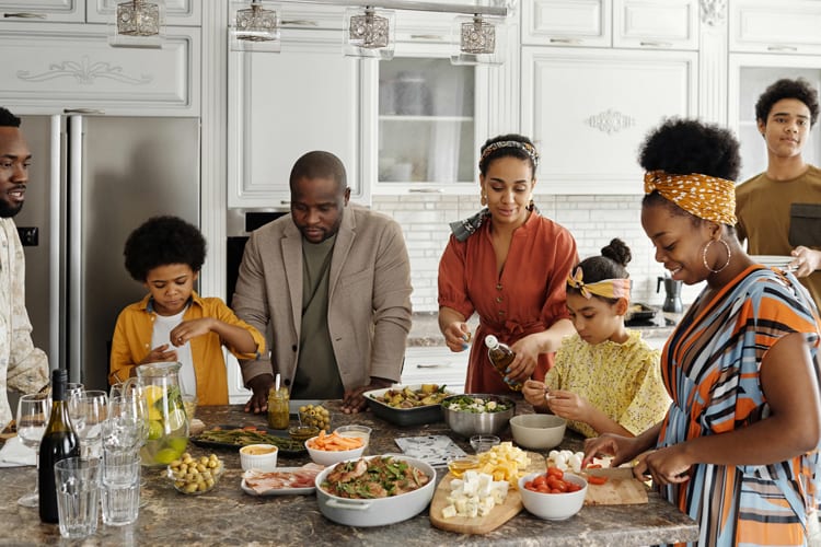 A family gathered around food in a kitchen