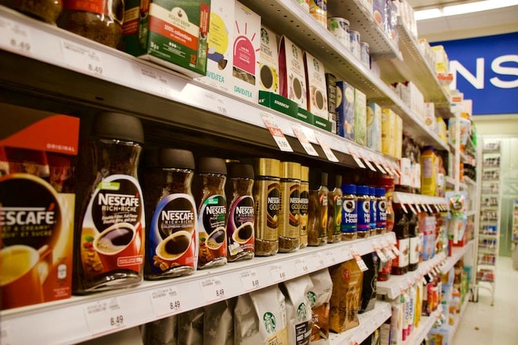 Coffee and creamer lined up on grocery store shelves