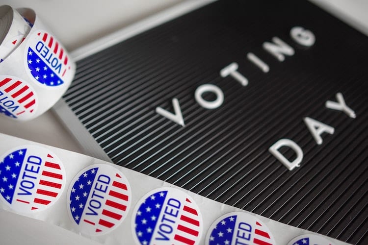 Letterboard with the words Voting Day on it next to a roll of I Voted stickers