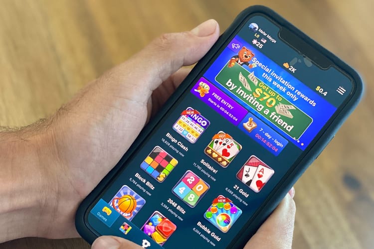 Male hand holding iPhone playing Pocket7Games