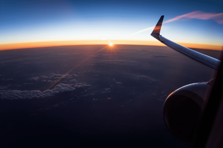 Plane Flying Over Sunrise