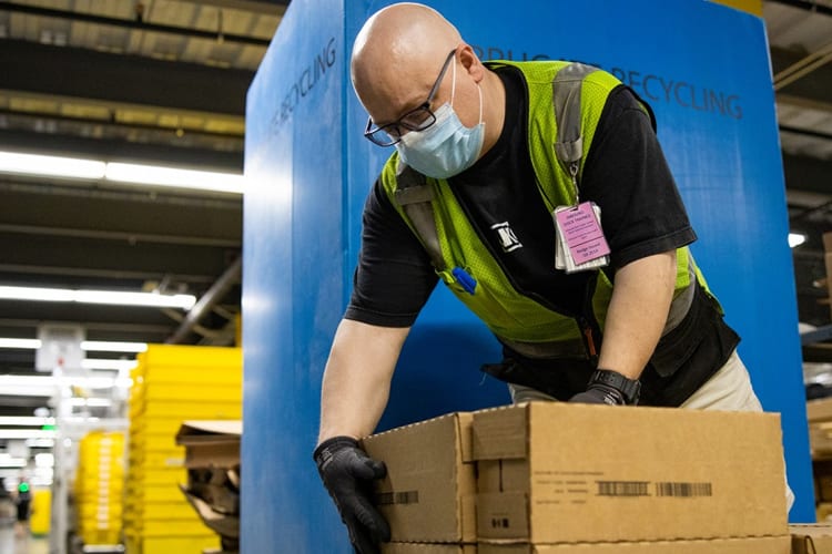 Amazon warehouse worker picking up boxes