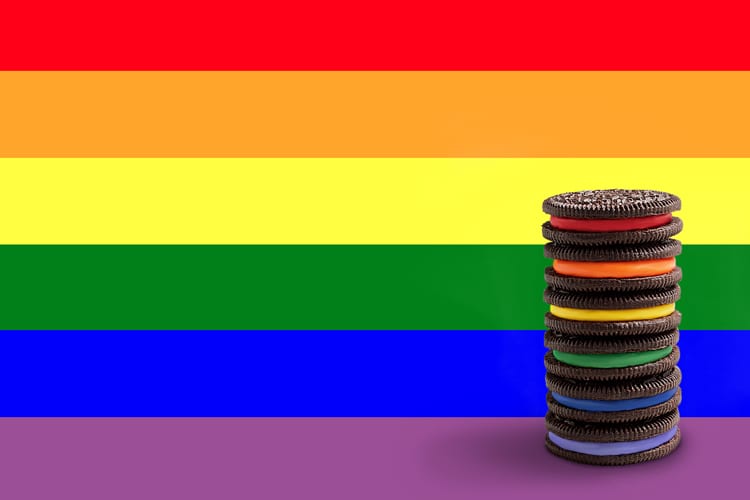 Rainbow background with a stack of rainbow Oreo cookies to symbolize LGBTQ Month