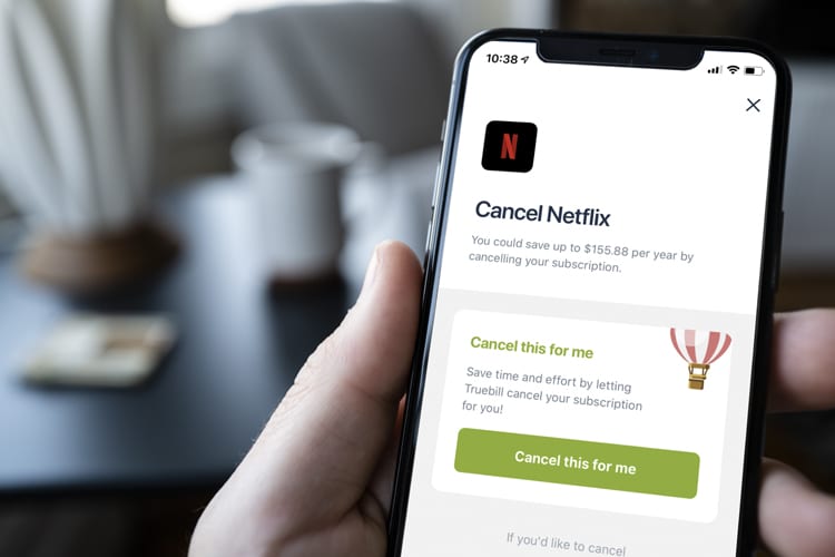Hand holding an iPhone that has Truebill showing Netflix cancellation