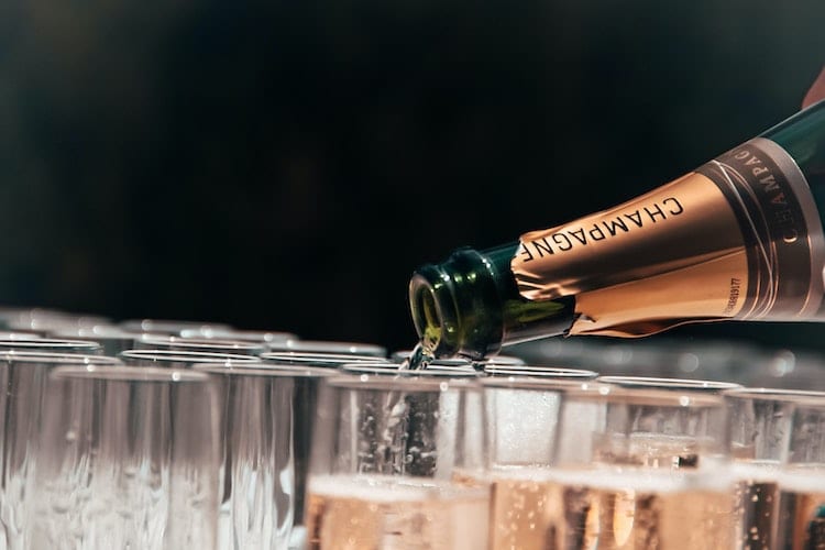 A bottle of champagne pouring into glasses