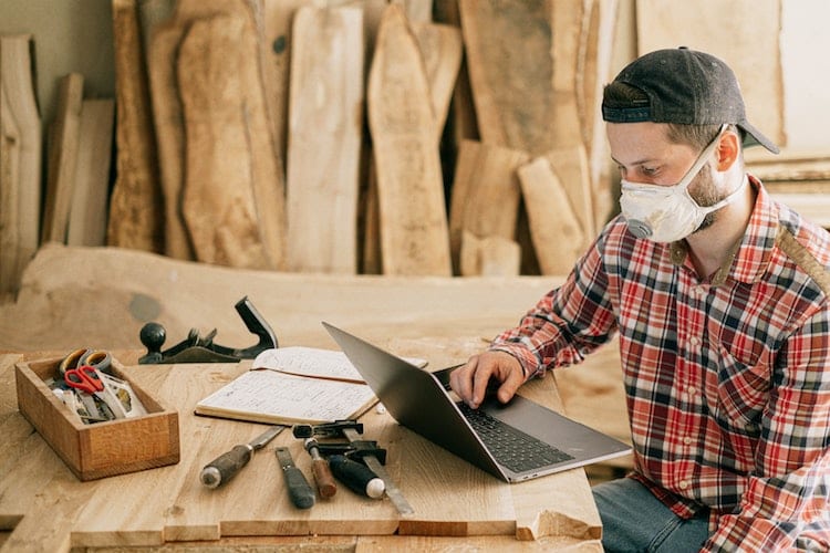 A contractor in a flannel shirt looking at a laptop