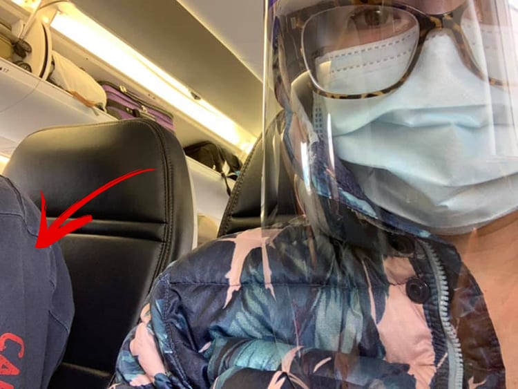 Masked woman wearing a face shield on a plane