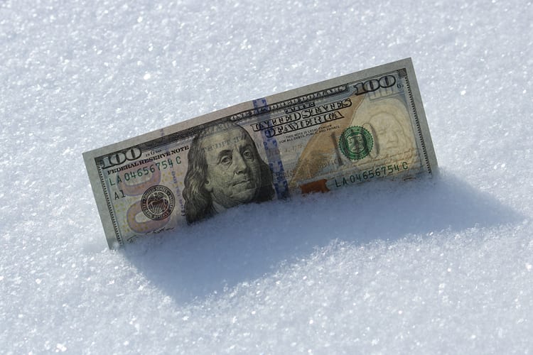 One hundred dollar bill in fresh snow