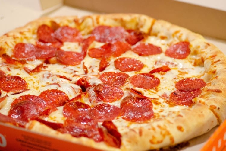 A pepperoni pizza pie in a takeout box