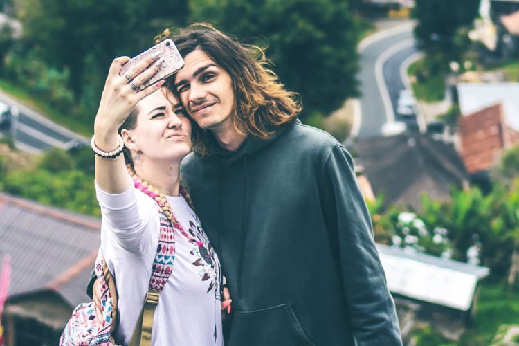 Young couple taking a selfie with landscape backdrop