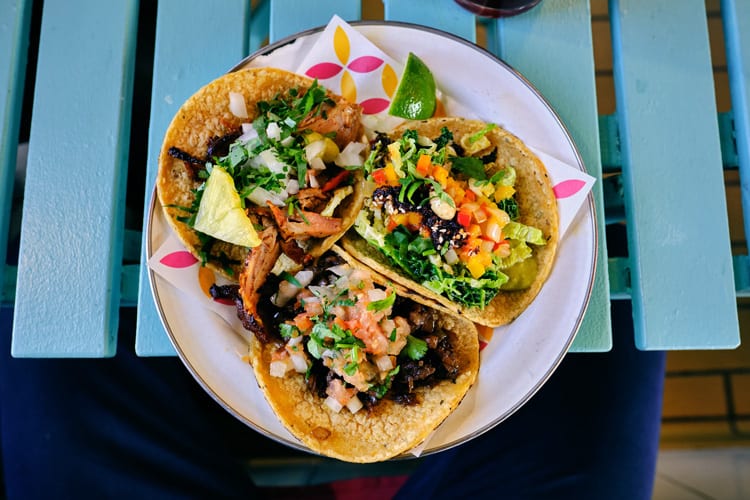 Plate of tacos on blue picnic table